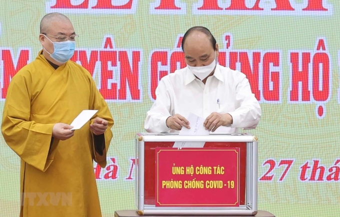 Chủ tịch nước Nguyễn Xuân Phúc quyên góp ủng hộ phòng, chống dịch COVID- 19. (Ảnh: Thống Nhất/TTXVN)