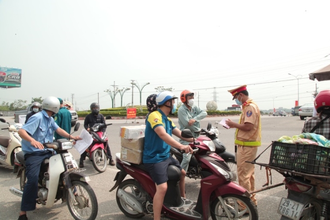 Các lực lượng chức năng kiểm soát người, phương tiện ra vào thành phố Vĩnh Yên tại chốt kiểm soát trên Quốc lộ 2 vòng xuyến Quất Lưu, huyện Bình Xuyên.