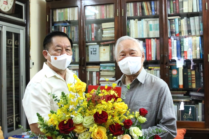 Trưởng Ban Tuyên giáo Trung ương Nguyễn Trọng Nghĩa tặng hoa chúc mừng nhà báo lão thành Phan Quang