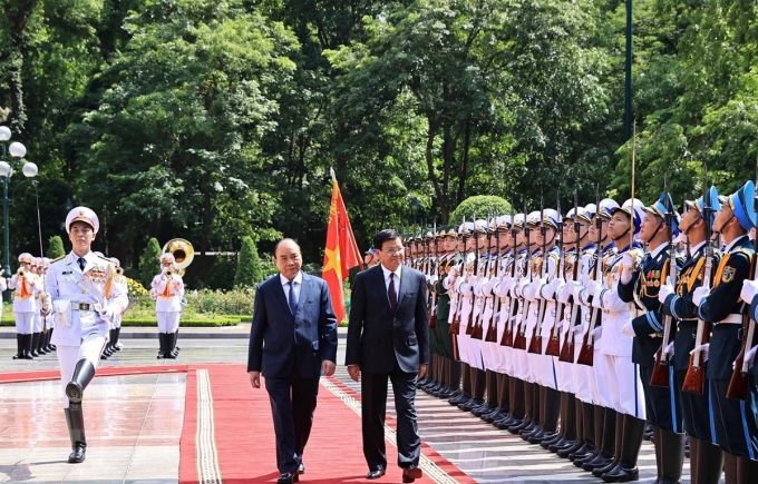 Chủ tịch nước Nguyễn Xuân Phúc và Tổng Bí thư Ban Chấp hành Trung ương Đảng Nhân dân Cách mạng Lào, Chủ tịch nước Cộng hòa Dân chủ Nhân dân Lào Thongloun Sisoulith duyệt Đội danh dự Quân dội nhân dân Việt Nam. (Ảnh: TTXVN)