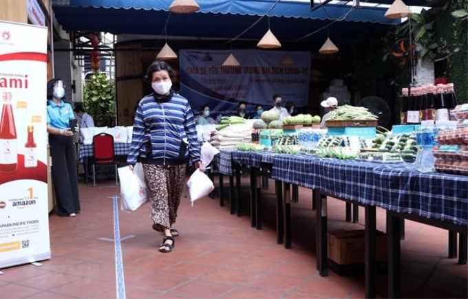 Người dân TP Hồ Chí Minh nhận nhu yếu phẩm, lương thực tại Siêu thị 0 đồng. (Ảnh: Xuân Khu/TTXVN)