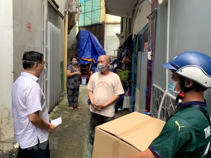 Bí thư Quận ủy quận 3 Phạm Thành Kiên thăm hỏi, tặng quà cho công nhân, người nghèo tại địa phương. (Ảnh: Thanh Vũ/TTXVN)