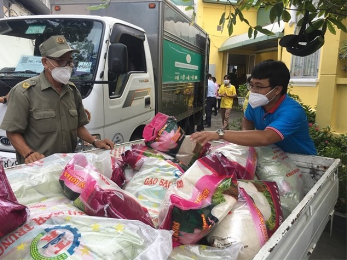 Tiếp nhận và vận chuyển, hàng hóa, quà tặng cho người dân ở 14 phường, quận 3. (Ảnh: Thanh Vũ/TTXVN)