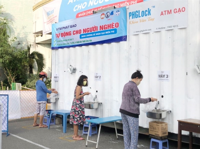 Người dân đến nhận gạo tại “ATM gạo” Quận 12 (TP. Hồ Chí Minh).