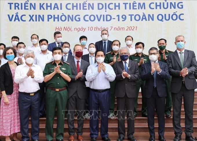Thủ tướng Chính phủ Phạm Minh Chính và các đại biểu tham dự Lễ phát động triển khai chiến dịch tiêm chủng vắc xin phòng COVID-19 toàn quốc. Ảnh: TTXVN