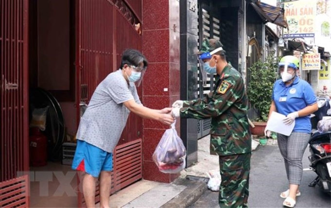 Cán bộ, chiên sỹ Sư đoàn 309 vận chuyển quà tặng nhu yếu phẩm sinh hoạt đến cho người dân tại phường 6, quận Tân Bình. (Ảnh: TTXVN)