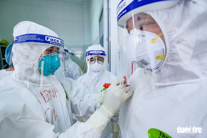 Các chuyên gia, y bác sĩ tại Bệnh viện Phổi Bắc Giang ghi tên mình trên áo bảo hộ để dễ dàng nhận biết nhau trước khi vào khu vực điều trị bệnh nhân mắc COVID-19 - Ảnh: NAM TRẦN