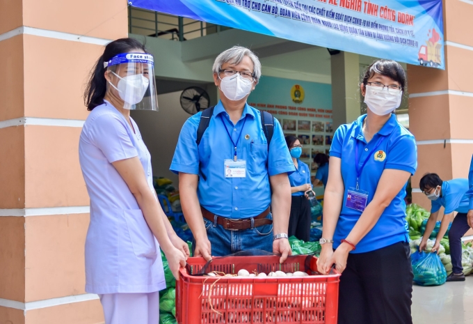 Đồng chí Nguyễn Thi Diệu Thúy - Chủ tịch LĐLĐ TP. Hồ Chí Minh (áo xanh, bên phải) tiếp nhận hỗ trợ đoàn viên, người lao động