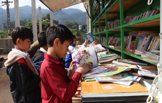 Các em học sinh vùng cao Sơn La được tiếp cận với nhiều loại sách báo bổ ích thông qua xe thư viện lưu động. (Ảnh: Hữu Quyết/TTXVN)