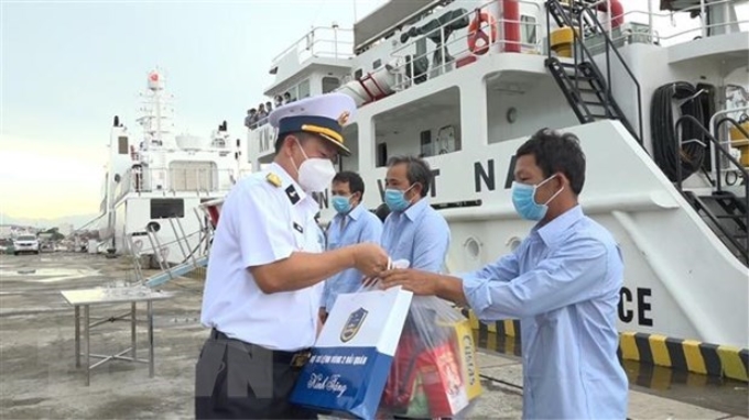 Đại tá Vũ Duy Lưu, Phó Chủ nhiệm Chính trị Vùng 2 Hải quân thăm hỏi, động viên, tặng quà ngư dân. (Ảnh: TTXVN phát)