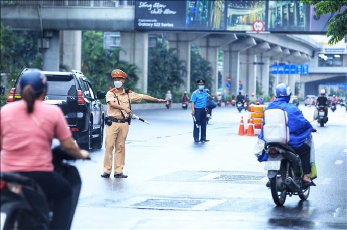 Lực lượng CSGT và Thanh tra giao thông tổ chức hướng dẫn phân làn các phương tiện trên đường Nguyễn Trãi. Ảnh: Tuấn Anh/TTXVN