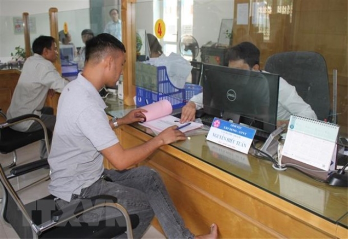 Người dân làm thủ tục hành chính tại bộ phận một cửa UBND thành phố Ninh Bình. (Ảnh: Hải Yến/TTXVN)