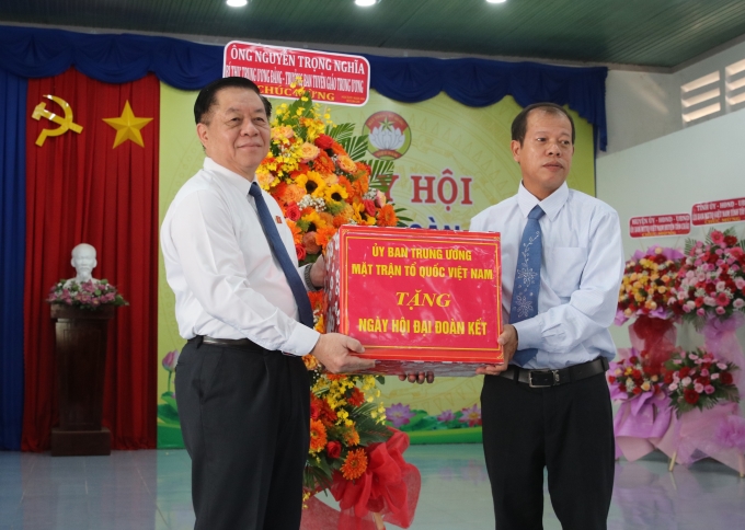 Đồng chí Nguyễn Trọng Nghĩa - Bí thư Trung ương Đảng, Trưởng Ban Tuyên giáo Trung ương tặng hoa và quà cho xã Tân Đông.(Ảnh: TA)
