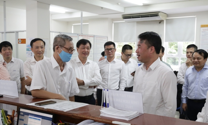 Tổng Giám đốc Nguyễn Thế Mạnh trao đổi với người dân đến làm việc qua tính năng đặt lịch làm việc trực tuyến tại bộ phận Một cửa BHXH TP.Hồ Chí Minh.