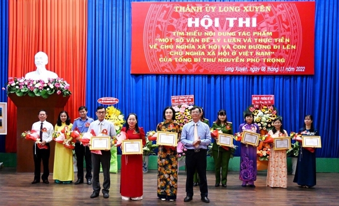 Đồng chí Bùi Văn Tặng, Phó Bí thư Thành ủy Long Xuyên, Chủ tịch HĐND thành phố trao Giấy Khen cho các thí sinh đạt giải Ba ở vòng 1