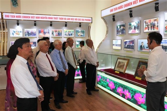 Các đại biểu tham quan khu vực trưng bày những bộ vật phẩm lưu niệm quý và hơn 3.000 hình ảnh do nguyên Chủ tịch nước Nguyễn Minh Triết trao tặng cho Bảo tàng tỉnh Bình Dương lưu giữ, trưng bày. (Ảnh: Chí Tưởng/TTXVN)