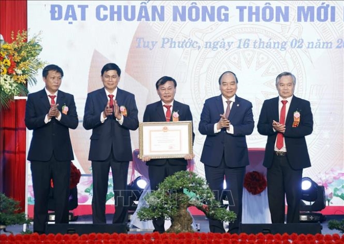 Chủ tịch nước Nguyễn Xuân Phúc trao Bằng chứng nhận huyện đạt chuẩn nông thôn mới cho lãnh đạo huyện Tuy Phước.