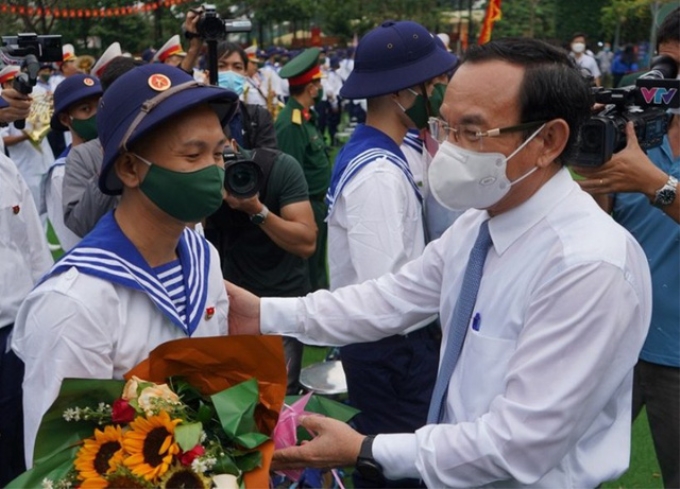 Đồng chí Nguyễn Văn Nên, Ủy viên Bộ Chính trị, Bí thư Thành ủy TP. Hồ Chí Minh tặng hoa, động viên các thanh niên lên đường nhập ngũ. (Ảnh: VGP)