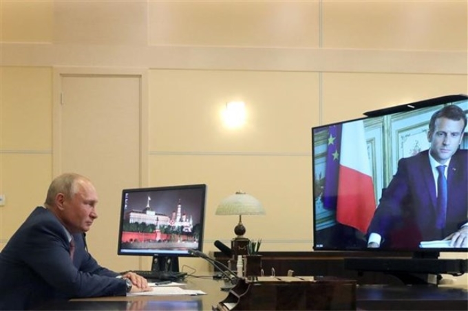 Tổng thống Nga Vladimir Putin và Tổng thống Pháp Emmanuel Macron (trên màn hình) trong một cuộc gặp trực tuyến, ngày 26/6/2020. (Ảnh: AFP/TTXVN)