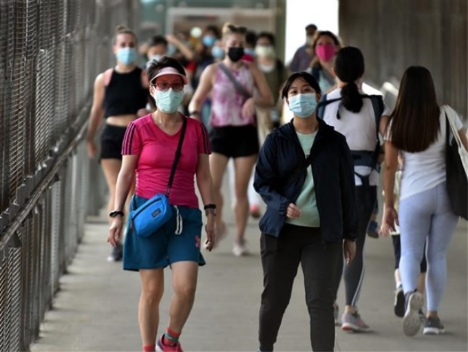 Người dân đeo khẩu trang phòng lây nhiễm COVID-19 tại Hong Kong (Trung Quốc). (Ảnh: THX/TTXVN)
