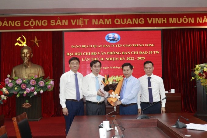 Đồng chí Phan Xuân Thuỷ, Uỷ viên Ban Thường vụ Đảng uỷ Cơ quan, Phó Trưởng ban Tuyên giáo Trung ương tặng hoa chúc mừng Chi ủy Chi bộ Văn phòng Ban Chỉ đạo 35 Trung ương nhiệm kỳ mới. (Ảnh: Phạm Cường)