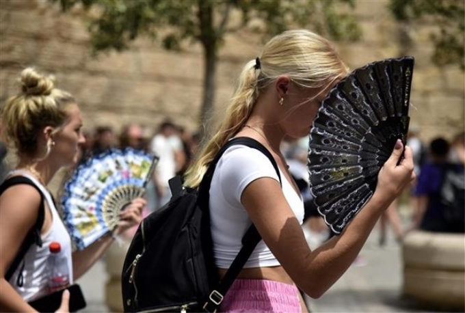 Người dân dưới trời nắng nóng tại Seville (Tây Ban Nha) ngày 13/6/2022. (Ảnh: AFP/TTXVN)