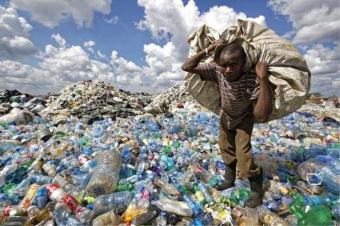 Một người đàn ông thu gom rác thải bán tái chế tại bãi rác khu ổ chuột Dandora ở Nairobi, Kenya. (Nguồn: phys.org)