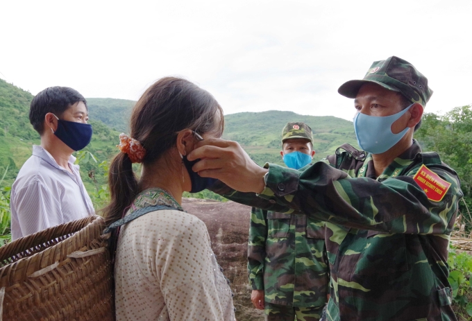 Bộ đội Biên phòng tỉnh Điện Biên phát khẩu trang miễn phí và hướng dẫn cách thức sử dụng đúng cách cho đồng bào đi nương tại khu vực biên tiếp giáp Lào và Trung Quốc_Ảnh: TTXVN