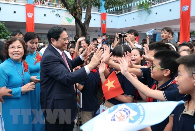 Thủ tướng Phạm Minh Chính với học sinh Trường Tiểu học Đoàn Thị Điểm. (Ảnh: TTXVN)