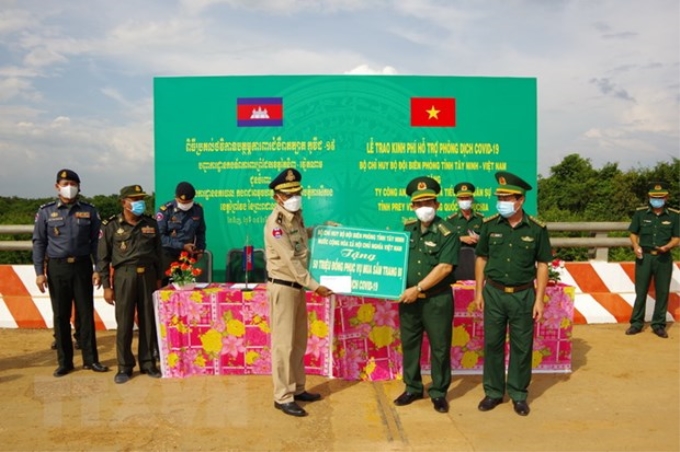 Đại tá Lê Hồng Vương, Chỉ huy trưởng Bộ đội Biên phòng trao Bảng tượng trưng 50 triệu cho Thiếu tướng Chăn Chon, Phó Giám đốc ty Công an tỉnh Srey Veng của Campuchia. (Ảnh: Thanh Tân/TTXVN)