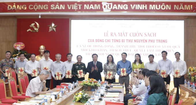 Đồng chí Nguyễn Xuân Thắng, Ủy viên Bộ Chính trị, Chủ tịch Hội đồng Lý luận Trung ương, Giám đốc Học viện Chính trị quốc gia Hồ Chí Minh tặng sách cho các đại biểu. (Ảnh: TA)