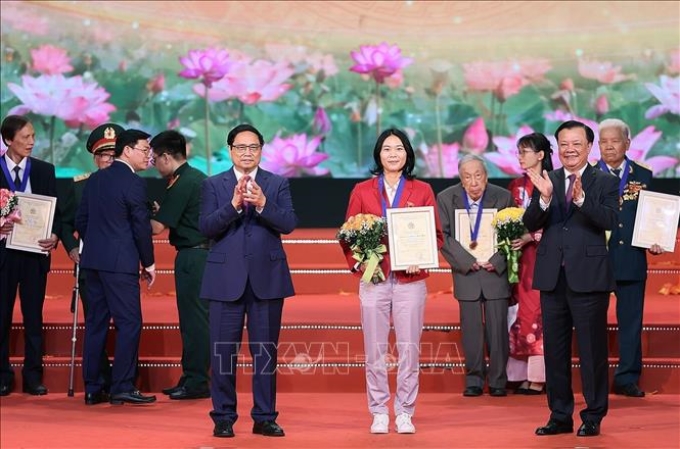 Thủ tướng Phạm Minh Chính và Bí thư Thành ủy Hà Nội Đinh Tiến Dũng trao danh hiệu “Công dân Thủ đô ưu tú” năm 2023 cho VĐV Phạm Hải Yến, Bộ môn bóng đá, Trung tâm Huấn luyện và thi đấu thể dục thể thao Hà Nội. Ảnh: Dương Giang/TTXVN