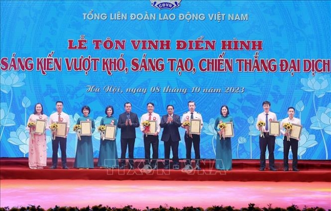 Thủ tướng Phạm Minh Chính và Chủ tịch Tổng LĐLĐ Việt Nam Nguyễn Đình Khang trao chứng nhận và hoa vinh danh các tác giả, nhóm tác giả có thành tích đặc biệt xuất sắc. Ảnh: Dương Giang/TTXVN