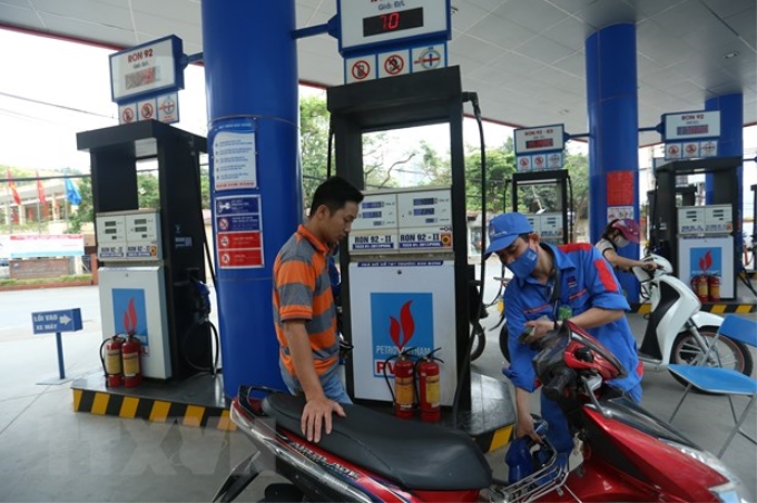 Khách hàng mua xăng tại cửa hàng của PVOIL tại Hà Nội. (Ảnh: Huy Hùng/TTXVN)