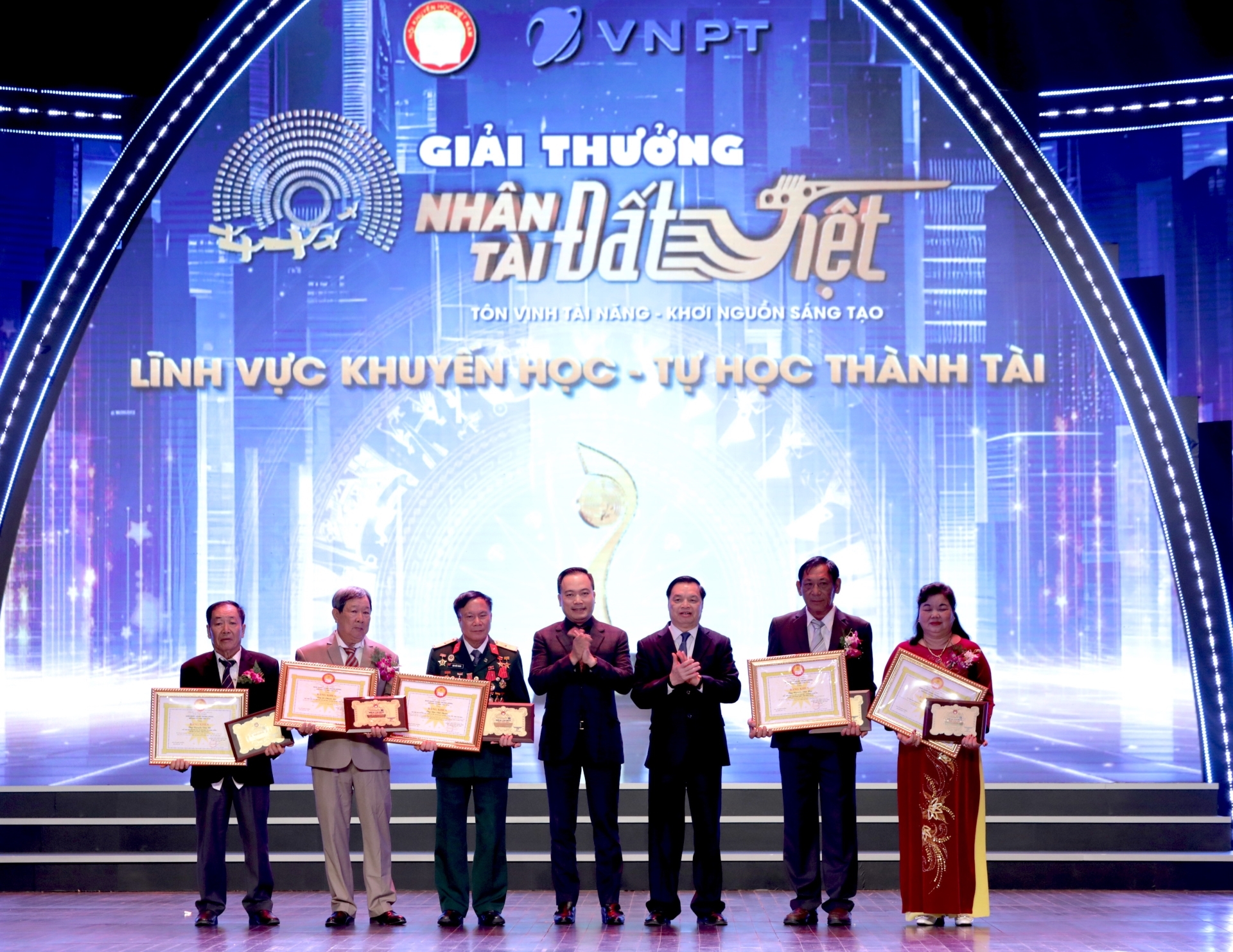 Ban Tổ chức trao giải thưởng cho nhóm tác giả trong lĩnh vực Tự học thành tài, giải thưởng Nhân tài Đất Việt lần thứ 17. (Ảnh: TA)