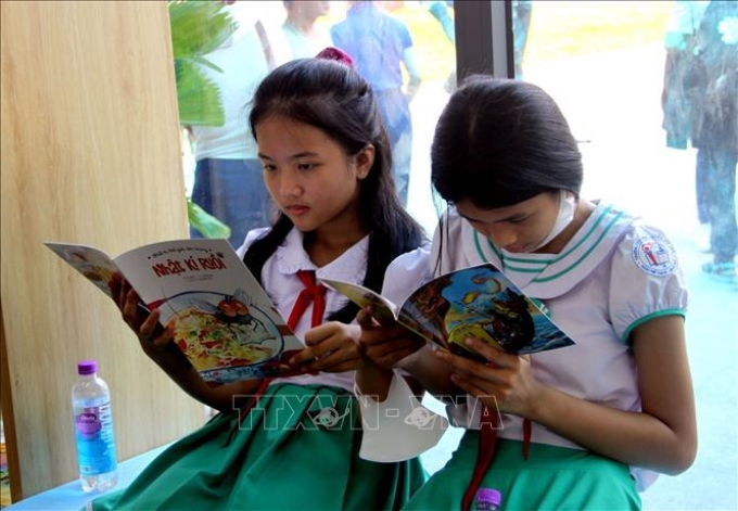 Các em nhỏ đọc sách tại Thư viện số cộng đồng Tam Kỳ (Quảng Nam). Ảnh: Trịnh Bang Nhiệm/TTXVN