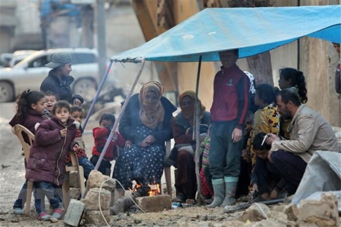 Người dân đốt lửa sưởi ấm trong thời tiết giá lạnh do bị mất nhà cửa sau trận động đất tại Jindayris, Syria. (Ảnh: AFP/TTXVN)