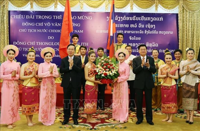 Tổng Bí thư, Chủ tịch nước Lào Thongloun Sisoulith và Chủ tịch nước Võ Văn Thưởng tặng hoa cho các nghệ sỹ hai nước biểu diễn nghệ thuật chào mừng tại tiệc chiêu đãi. Ảnh: Thống Nhất/TTXVN.
