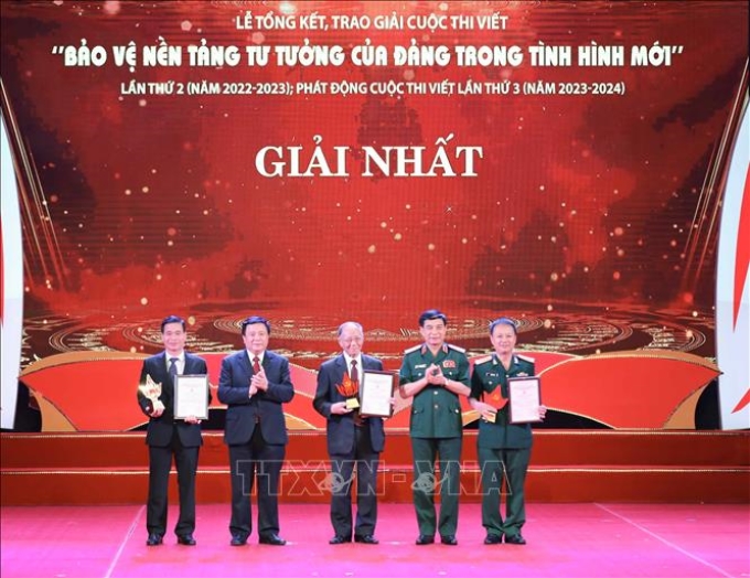 Đại tướng Phan Văn Giang, Ủy viên Bộ Chính trị, Bộ trưởng Bộ Quốc phòng cùng đồng chí Nguyễn Xuân Thắng, Ủy viên Bộ Chính trị, Giám đốc Học viện Chính trị quốc gia Hồ Chí Minh, Chủ tịch Hội đồng Lý luận Trung ương trao giải Nhất cho các tác giả. Ảnh: Thanh Tùng/TTXVN