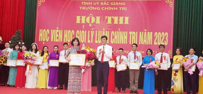 Đồng chí Bùi Thế Chung - Hiệu trưởng trường Chính trị Bắc Giang trao giải nhất cho thí sinh Hoàng Thị Chung.