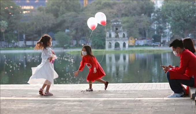 Nhiều gia đình cho con đi chơi tại hồ Gươm trước khoảnh khắc chuyển giao năm mới Tân Sửu 2021. Ảnh: Thanh Tùng /TTXVN
