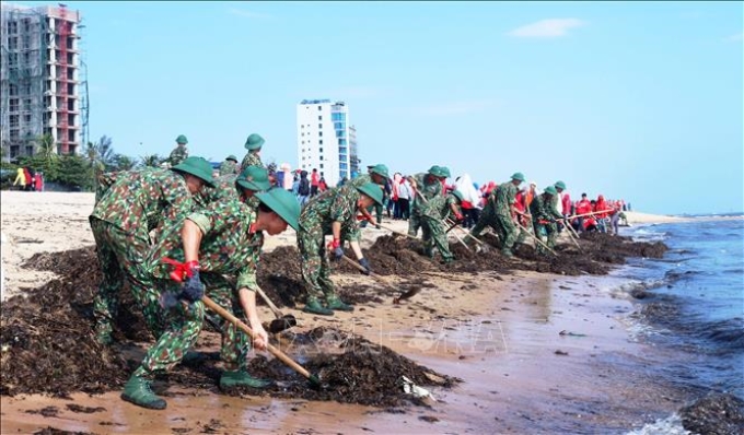 Lực lượng vũ trang tỉnh Quảng Bình ra quân chiến dịch thu dọn rác trên bãi biển trong chương trình “Hãy làm sạch biển - Tử tế với đại dương”. Ảnh: Võ Dung/TTXVN