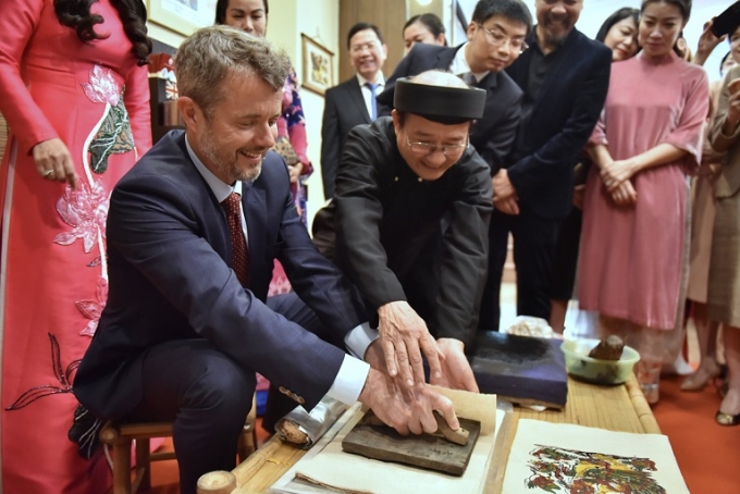 Thái tử kế vị Đan Mạch Frederik được nghệ nhân hướng dẫn cách in tranh Đông Hồ trong chuyến thăm chính thức Việt Nam, tháng 11/2022 - chuyến thăm là một phần của hoạt động kỷ niệm 50 năm Ngày thiết lập quan hệ ngoại giao Đan Mạch và Việt Nam. (Nguồn: zing.vn)