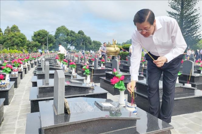 Trưởng Ban Nội chính Trung ương Phan Đình Trạc thắp hương các phần mộ liệt sĩ tại Nghĩa trang Liệt sĩ tỉnh Đắk Lắk. Ảnh: TTXVN phát