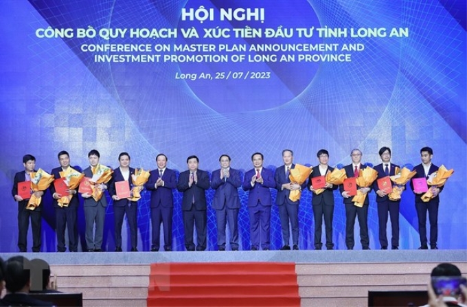 Thủ tướng Phạm Minh Chính chứng kiến trao chứng nhận đăng ký đầu tư của tỉnh Long An cho các nhà đầu tư. (Ảnh: TTXVN)