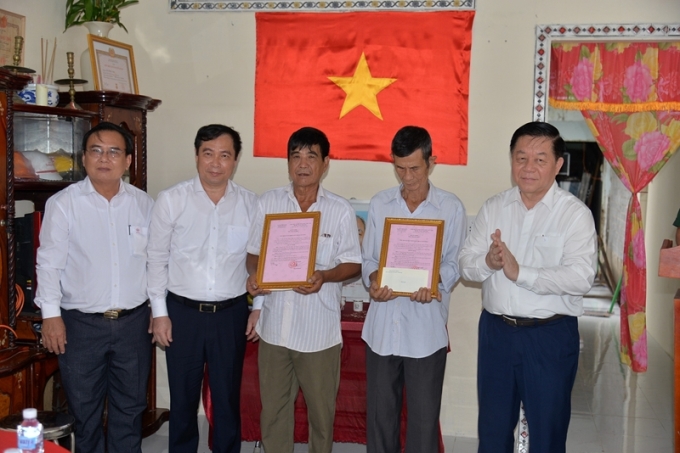 Đồng chí Nguyễn Trọng Nghĩa (bìa phải) và lãnh đạo bàn giao 2 nhà tình nghĩa cho ông Lê Công Tâm và ông Nguyễn Văn Thanh.