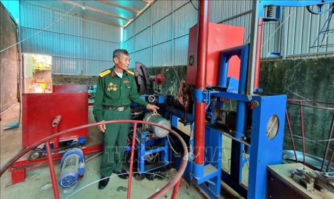 Cựu chiến binh Nguyễn Chí Tạch với dây chuyền sản xuất thép gai, lưới B40.
