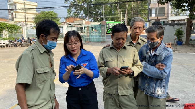 Đoàn viên thanh niên hướng dẫn các tiện ích của “Tây Ninh Smart” cho cán bộ công chức, người lao động của phường.