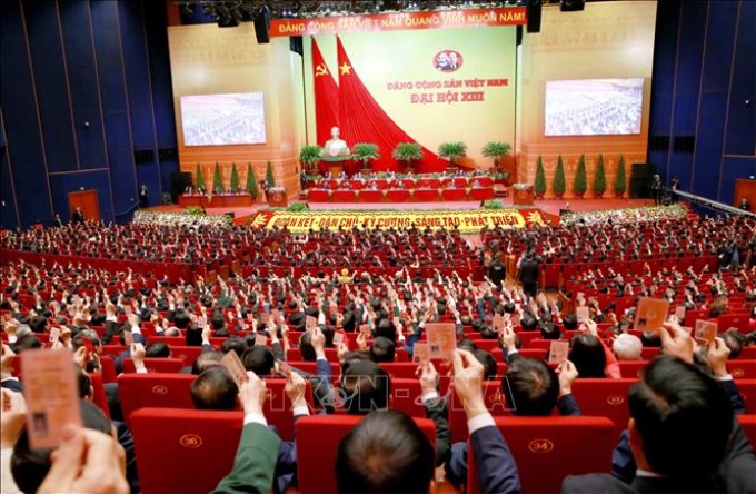Các đại biểu biểu quyết, thông qua Nghị quyết Đại hội XIII của Đảng. Ảnh (tư liệu): TTXVN