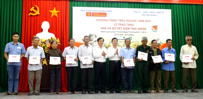 Đồng chí Phan Xuân Thủy và đồng chí Trần Văn Huyến trao sổ tiết kiệm tình nghĩa cho các hộ gia đình chính sách